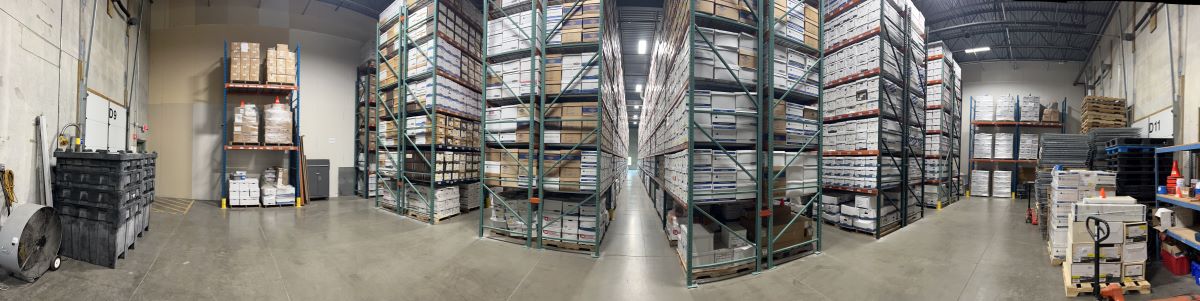 A panoramic photo of the inside of a records storage facility that shows thousands of archive boxes stored on tall racks.