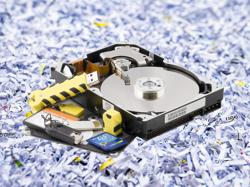 A hard drive is sitting on top of a pile of shredded paper.